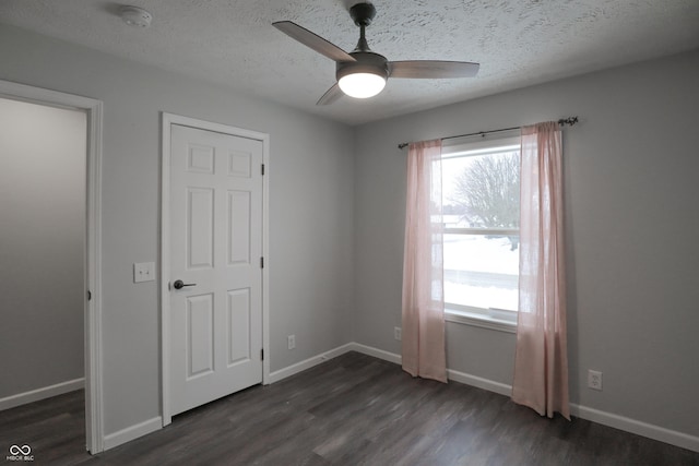 unfurnished bedroom with dark hardwood / wood-style flooring, ceiling fan, and a textured ceiling