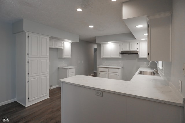 kitchen featuring white cabinetry, sink, and kitchen peninsula