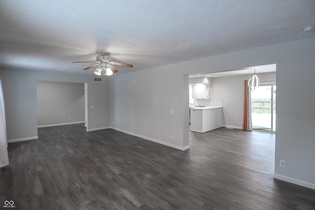 unfurnished living room featuring dark hardwood / wood-style flooring, ceiling fan, and a textured ceiling