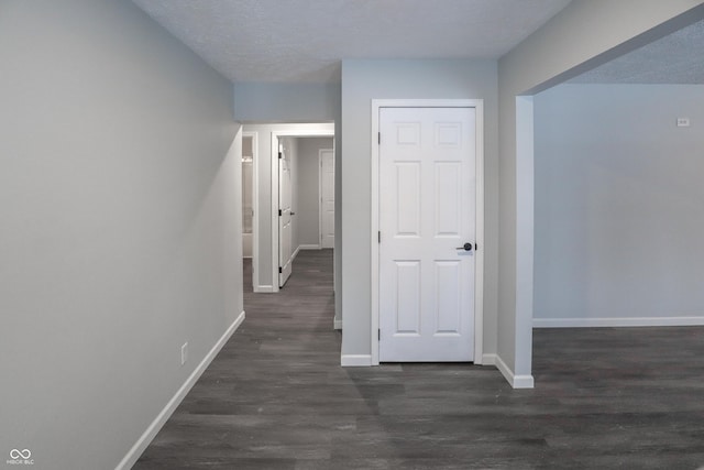 corridor featuring dark hardwood / wood-style floors and a textured ceiling