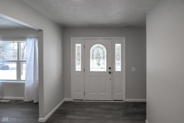 foyer entrance featuring dark hardwood / wood-style floors and a textured ceiling