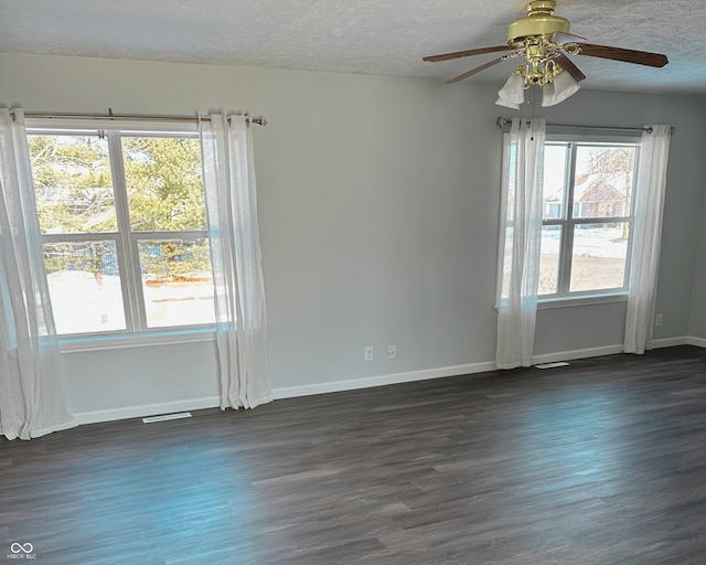 empty room with ceiling fan, dark hardwood / wood-style floors, and a textured ceiling