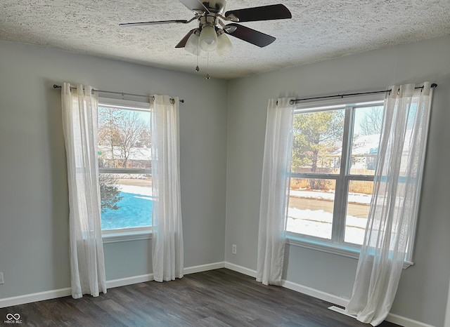 unfurnished room featuring a wealth of natural light and dark hardwood / wood-style floors