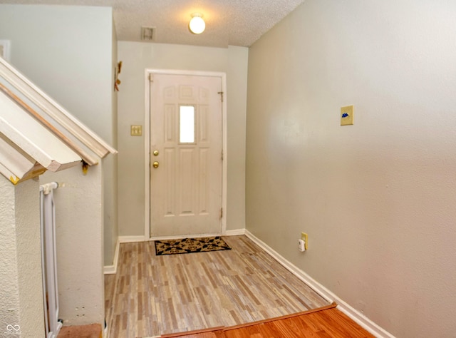 foyer featuring a textured ceiling and light hardwood / wood-style floors