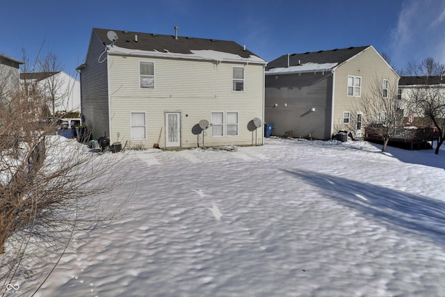 view of snow covered rear of property