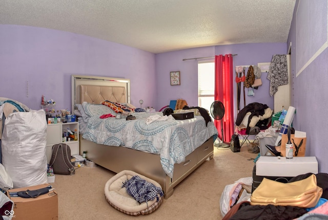 bedroom with light colored carpet and a textured ceiling