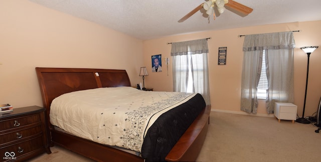 bedroom featuring ceiling fan, a textured ceiling, and light carpet