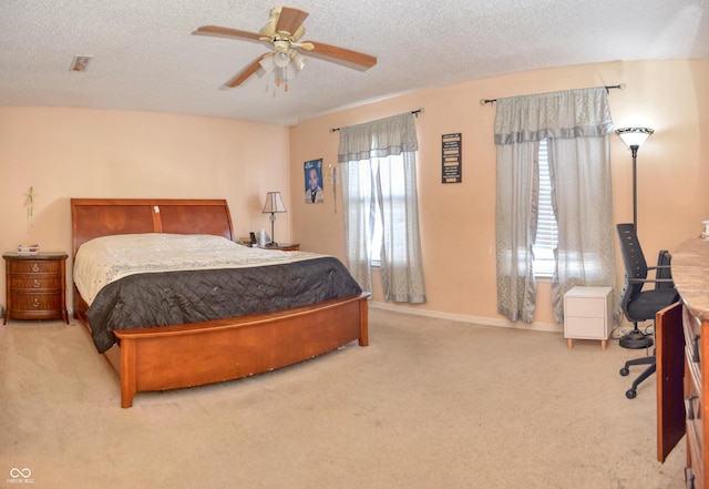 carpeted bedroom with ceiling fan and a textured ceiling