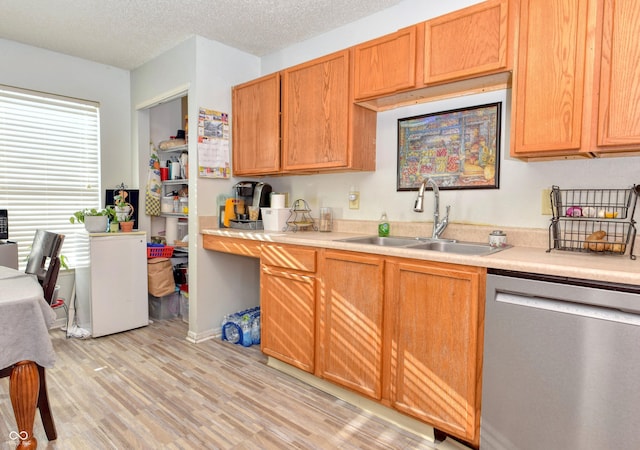 kitchen featuring sink, a textured ceiling, dishwasher, and light hardwood / wood-style flooring