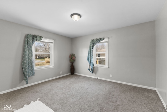 spare room featuring plenty of natural light, baseboards, and carpet flooring