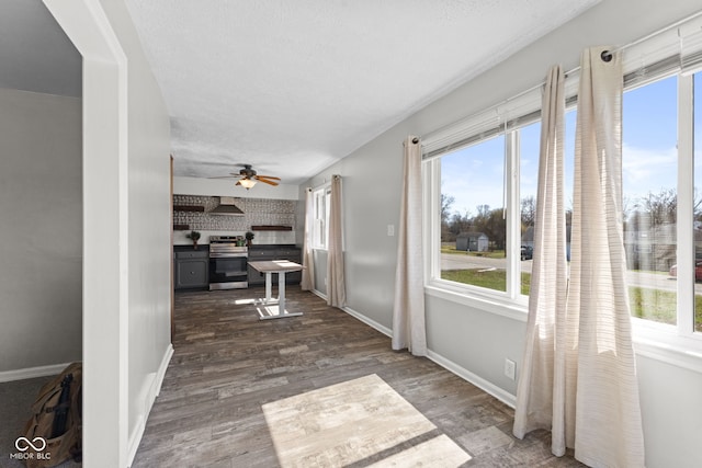 corridor featuring dark wood-style floors, baseboards, and a textured ceiling
