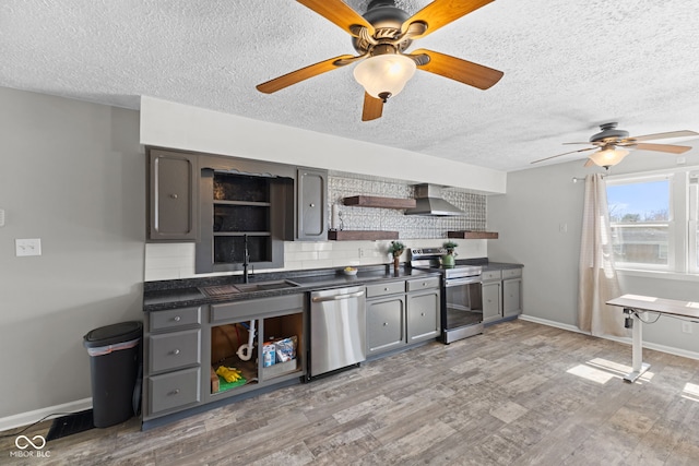 kitchen with open shelves, dark countertops, ceiling fan, appliances with stainless steel finishes, and wall chimney exhaust hood