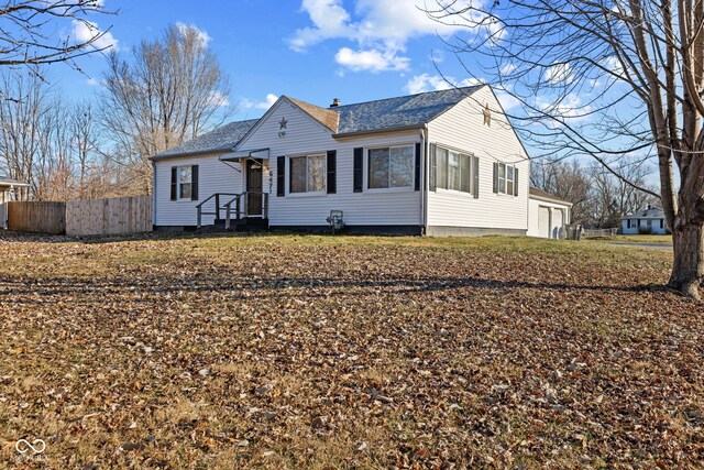 view of front of home with a shingled roof and fence