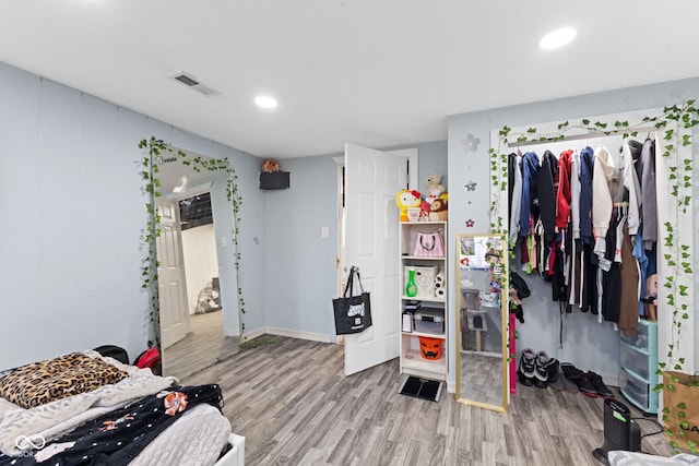 bedroom with baseboards, visible vents, recessed lighting, and wood finished floors
