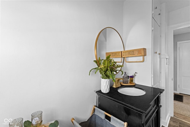 interior details featuring visible vents, wood finished floors, and vanity