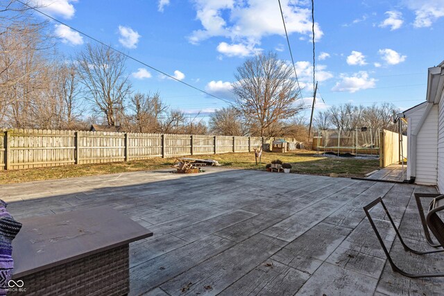 view of patio featuring a trampoline and a fenced backyard