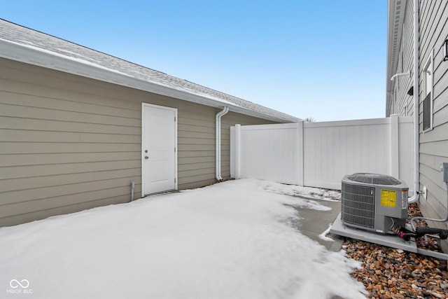 snow covered patio featuring central AC unit