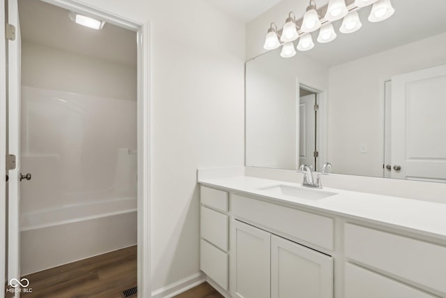 bathroom with hardwood / wood-style flooring, vanity, and  shower combination