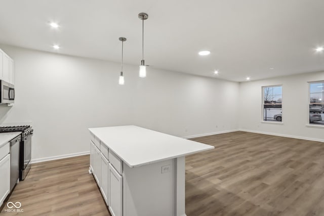 kitchen featuring white cabinetry, hanging light fixtures, hardwood / wood-style flooring, and a center island