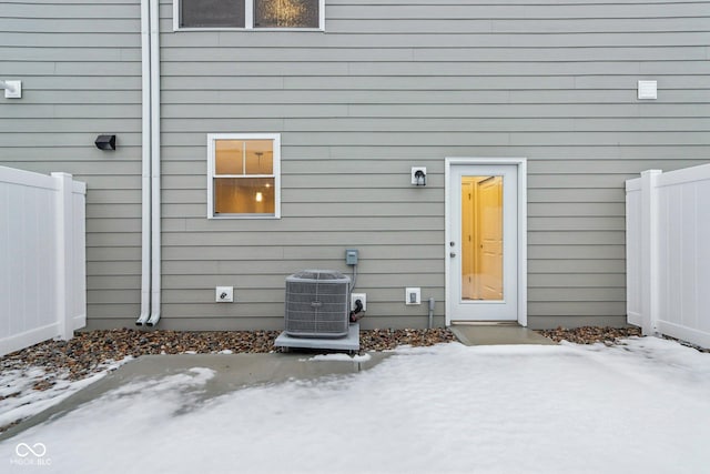 snow covered property entrance featuring central AC