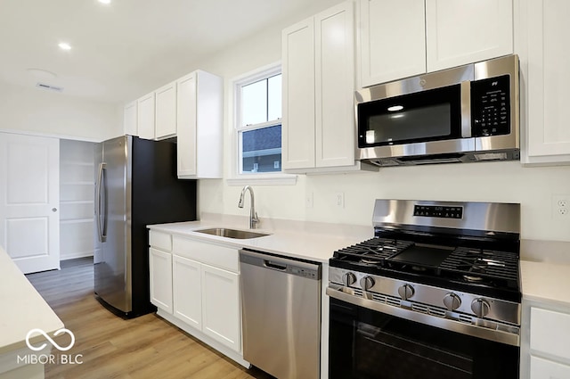 3921 Wren Dr, Brownsburg, IN 46112 - kitchen featuring stainless steel appliances, light countertops, white cabinets, light wood-style floors, and recessed lighting