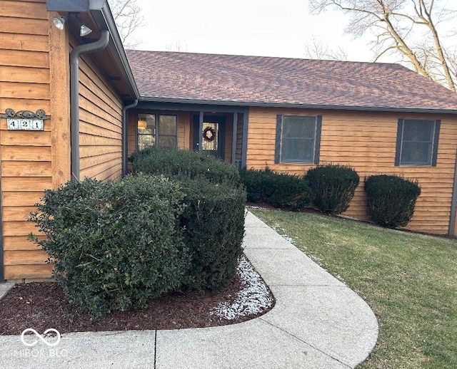 view of exterior entry with a lawn