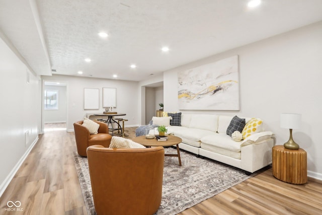 living room featuring a textured ceiling and light hardwood / wood-style floors