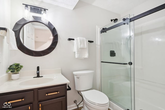 bathroom featuring a shower with door, vanity, a textured ceiling, and toilet