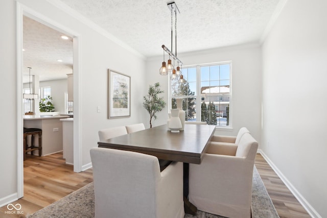 dining space featuring a textured ceiling, light wood-type flooring, and a healthy amount of sunlight