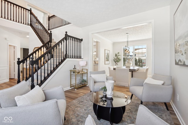 living room featuring a textured ceiling, a notable chandelier, and hardwood / wood-style flooring