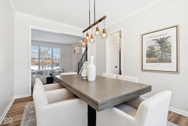 dining area with a chandelier, a textured ceiling, dark hardwood / wood-style floors, and ornamental molding