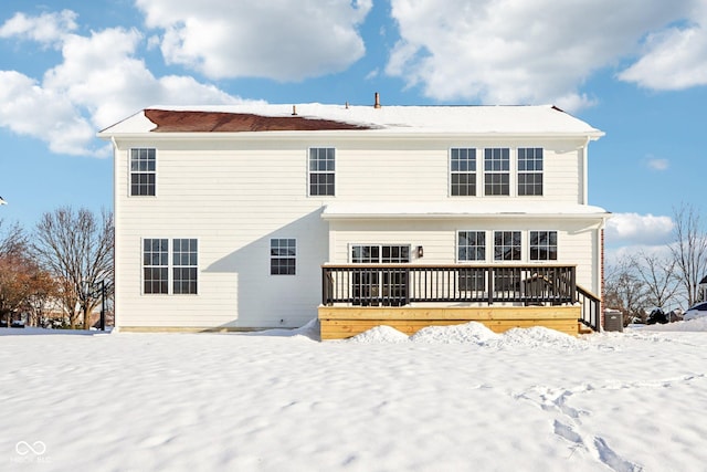 snow covered back of property featuring a wooden deck