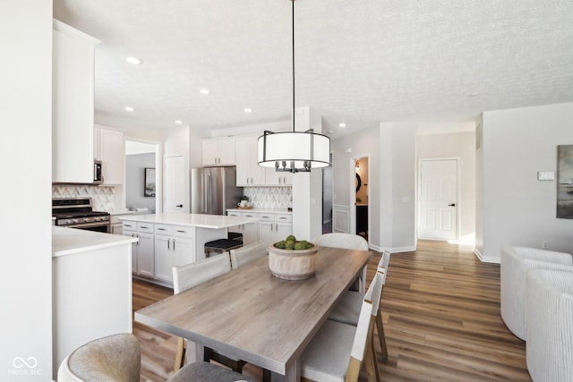 dining room with a textured ceiling, dark hardwood / wood-style floors, and an inviting chandelier