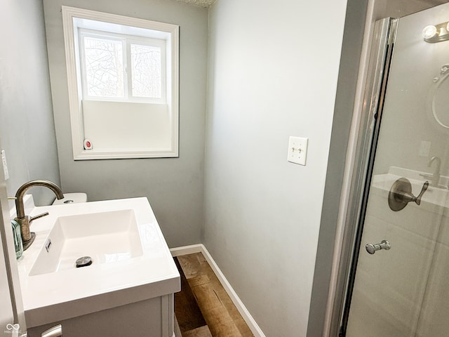 bathroom with an enclosed shower, vanity, and hardwood / wood-style flooring