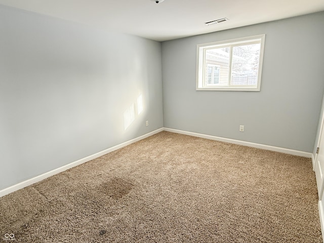 carpeted spare room featuring visible vents and baseboards