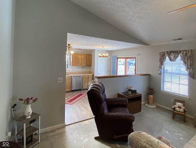 living room with ceiling fan with notable chandelier, lofted ceiling, a textured ceiling, and a healthy amount of sunlight