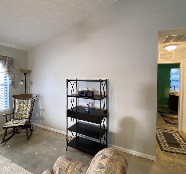 living area with a textured ceiling and concrete floors