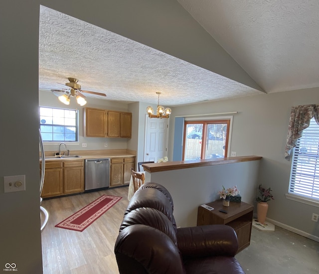 living room with a textured ceiling, ceiling fan with notable chandelier, a healthy amount of sunlight, and sink