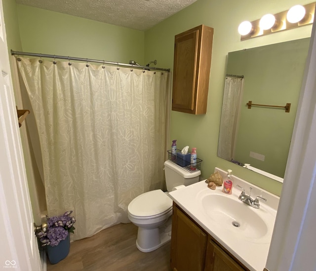 bathroom featuring vanity, wood-type flooring, a textured ceiling, and toilet