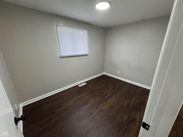 empty room with dark hardwood / wood-style flooring