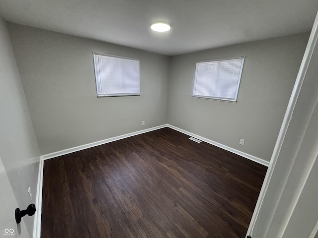 unfurnished room featuring dark wood-type flooring