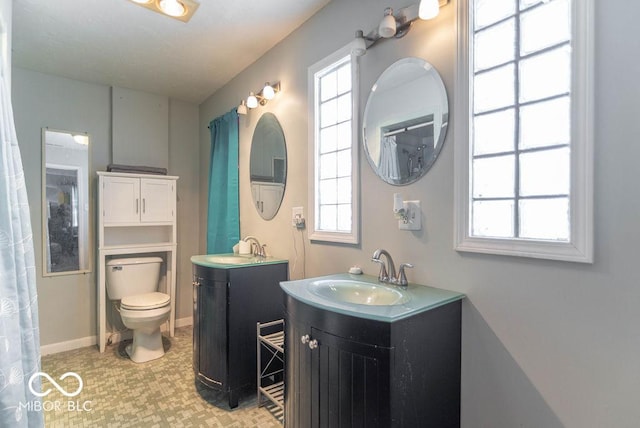 bathroom featuring vanity, toilet, and a healthy amount of sunlight