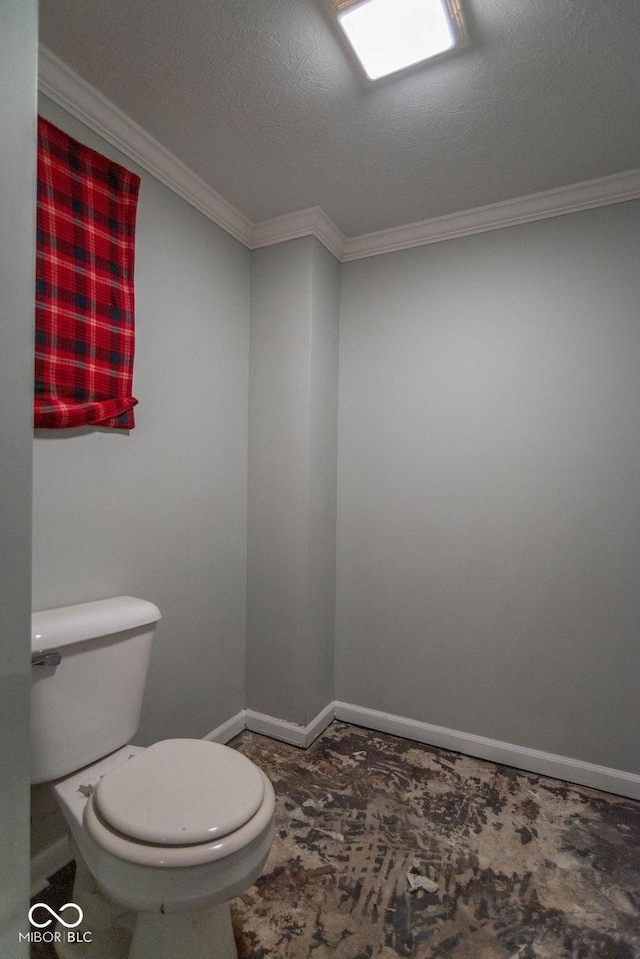 bathroom with toilet, ornamental molding, and a textured ceiling