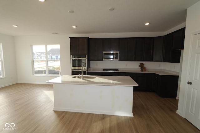 kitchen featuring appliances with stainless steel finishes, a center island with sink, and light hardwood / wood-style floors