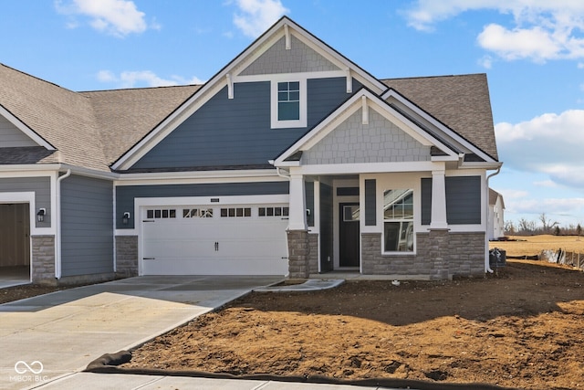 craftsman house with stone siding, driveway, a garage, and roof with shingles