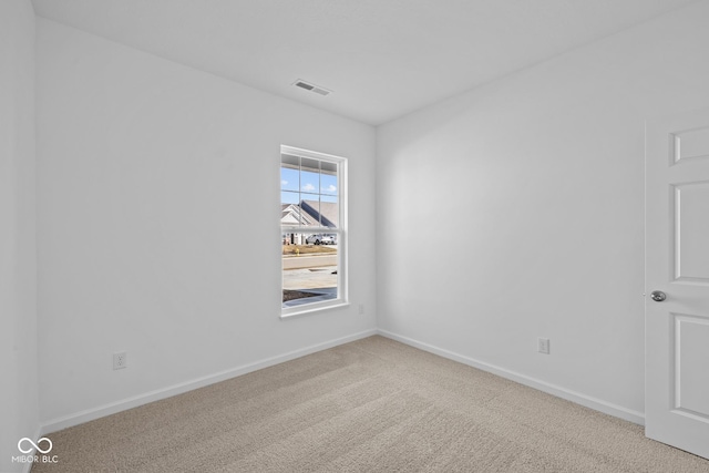 empty room featuring visible vents, baseboards, and carpet