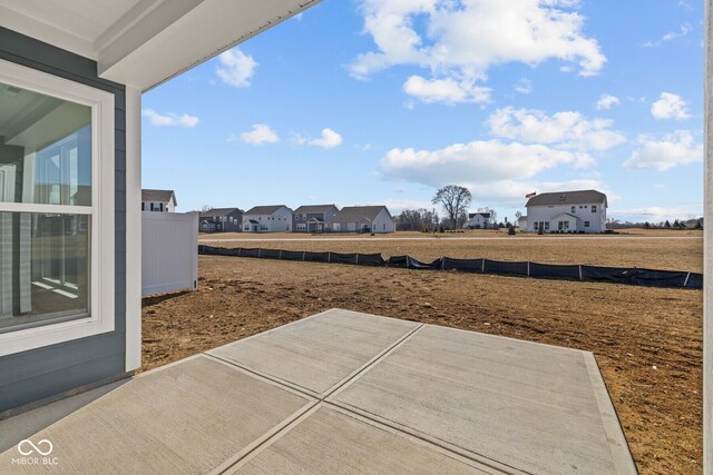 view of yard featuring a residential view, a patio, and fence