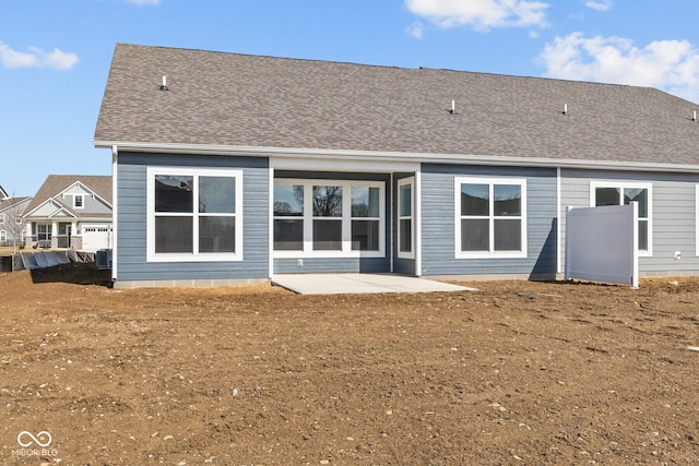 rear view of property with a patio and roof with shingles