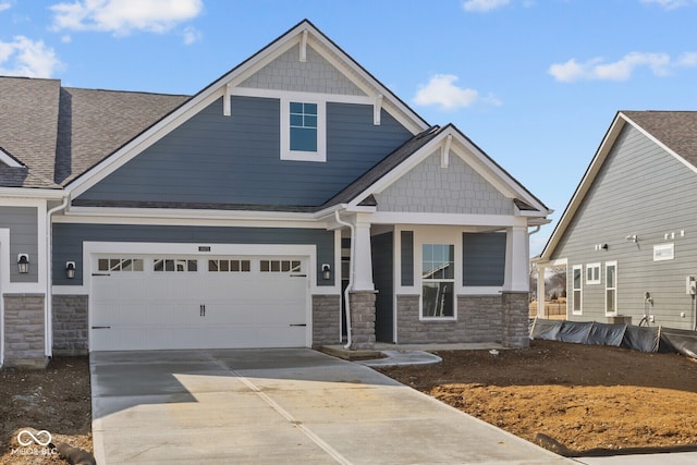 craftsman-style home featuring stone siding, roof with shingles, covered porch, concrete driveway, and a garage