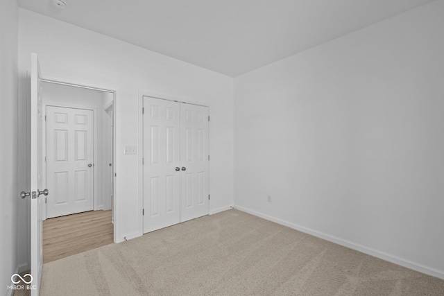 unfurnished bedroom with carpet, baseboards, and a closet